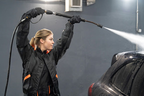 Young woman washing car