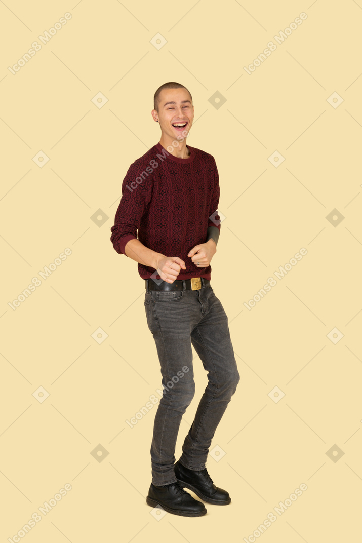 Vista di tre quarti di un giovane uomo che ride in pullover rosso