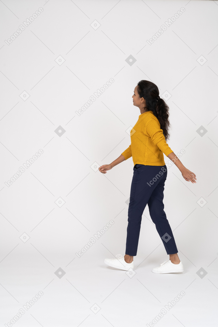 一个穿着休闲服的女孩走路的侧视图