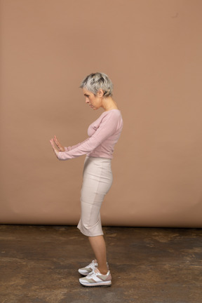 Vista lateral de uma mulher com roupas casuais mostrando um gesto de pare