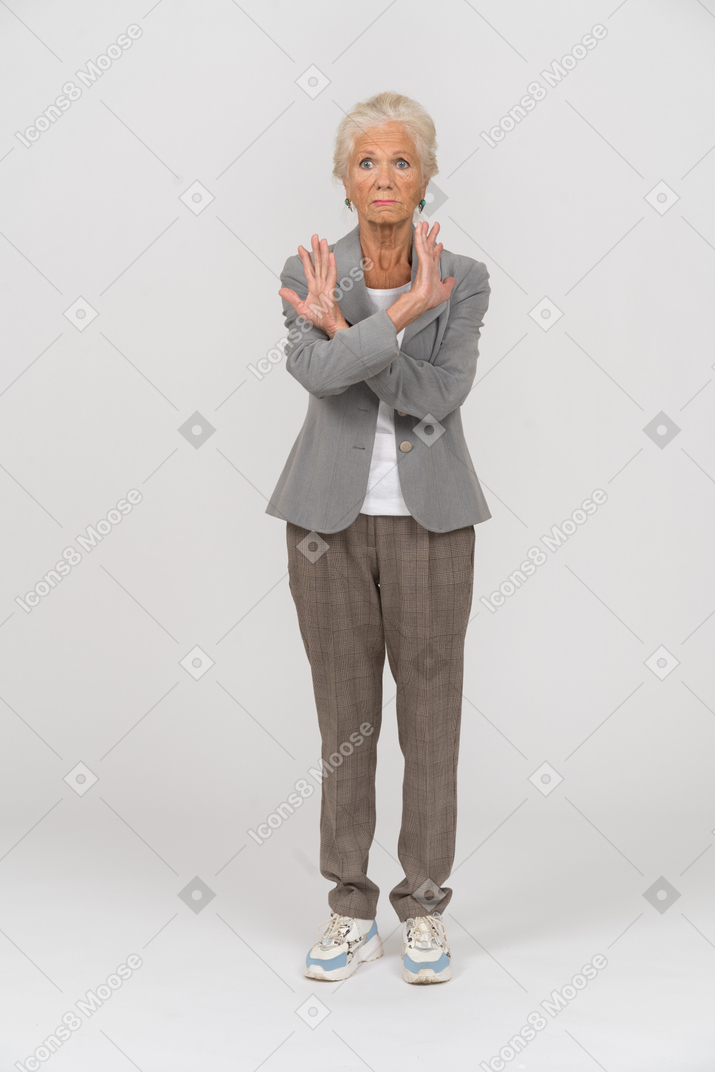 Front view of an old lady in suit showing stop sign