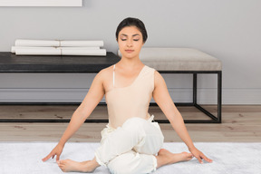 A woman sitting on the floor in a yoga position