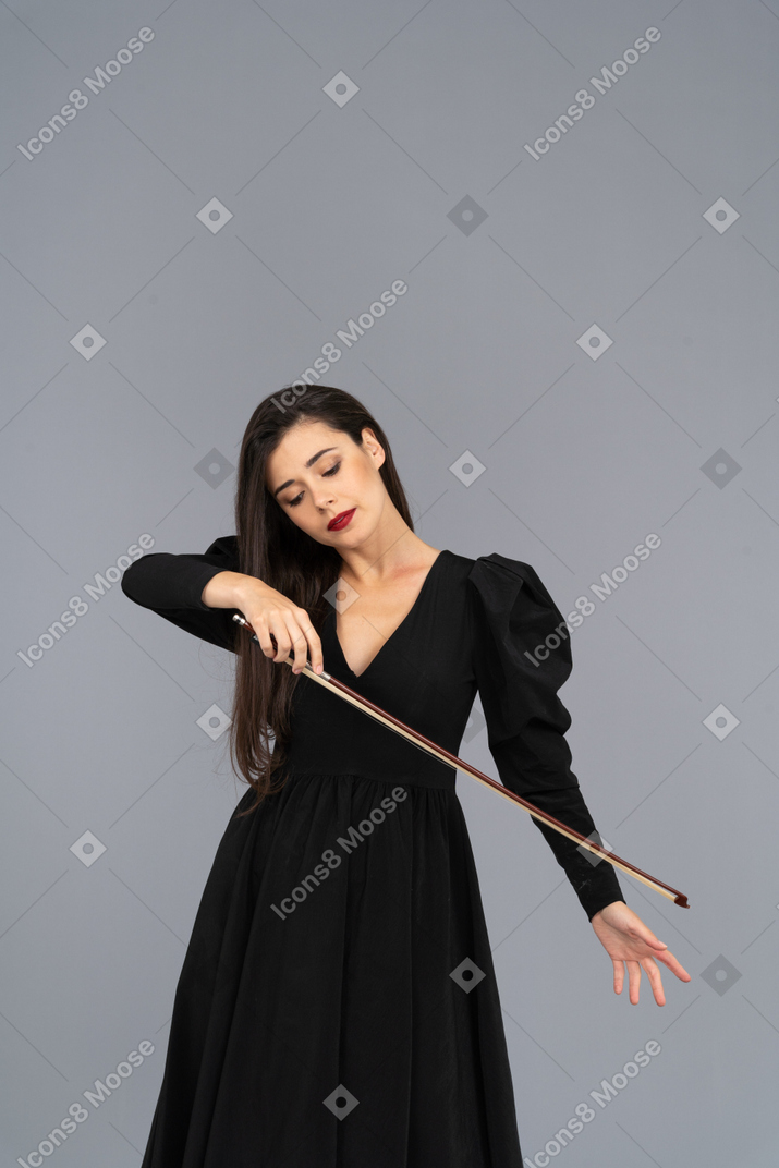 Vista frontale di una giovane donna in abito nero che tiene il fiocco