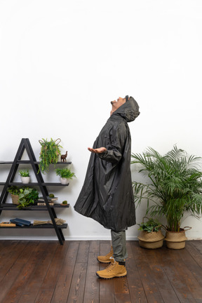 Homem de capa de chuva jogando a cabeça para trás