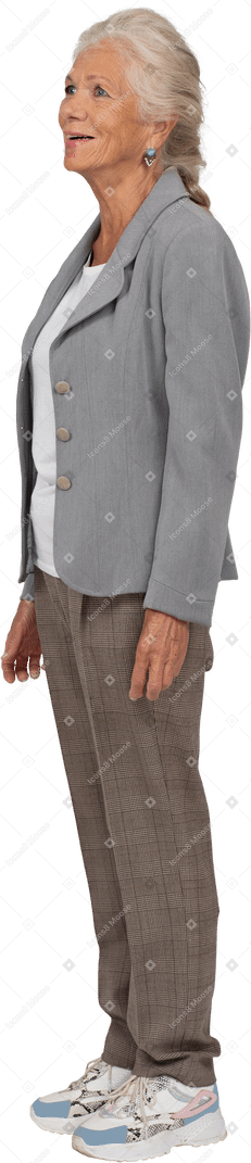 Вид сбоку счастливой старушки в сером пиджаке, смотрящей вверх