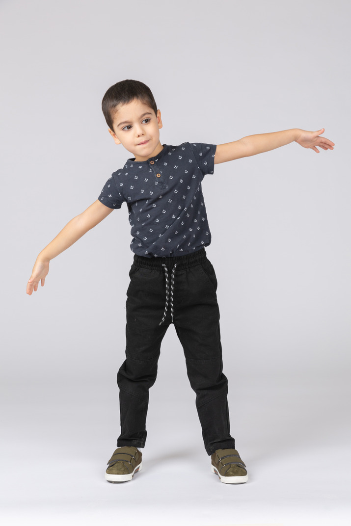 Front view of a cute boy posing with outstretched arms