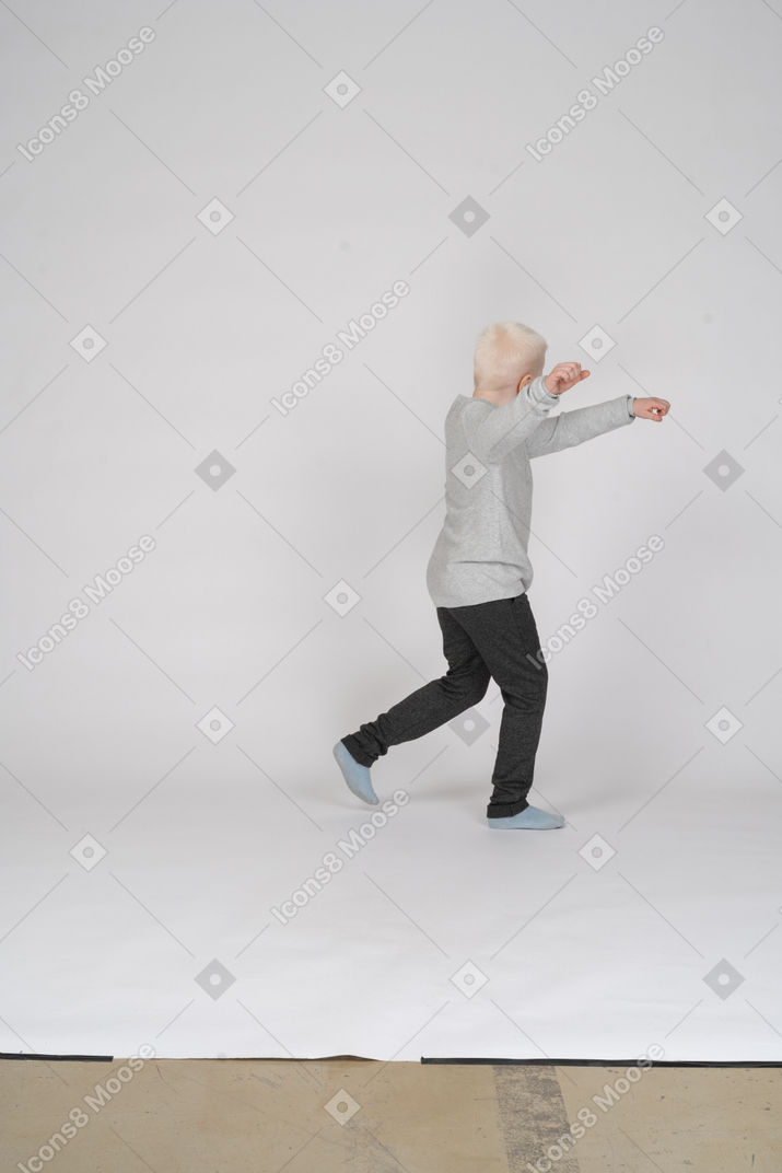 Side view of a boy running away