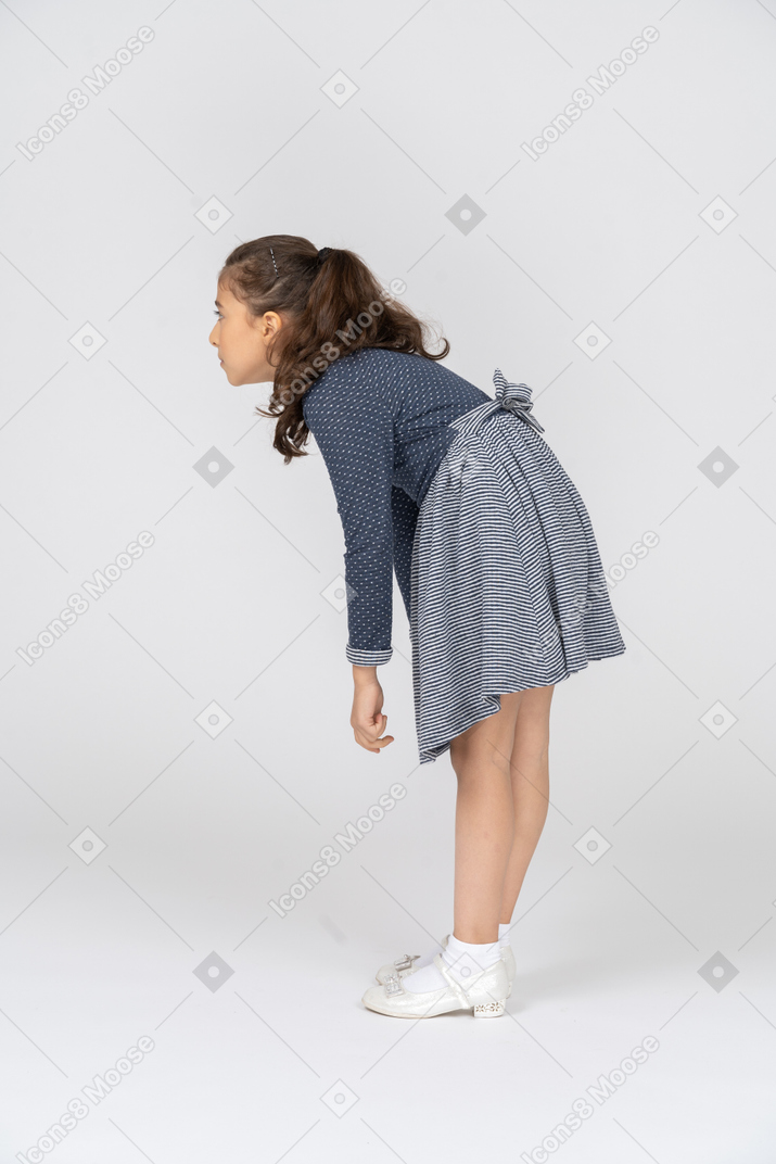 Vista lateral de una niña encorvada e inclinada hacia adelante