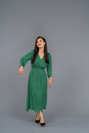 Front view of a greeting young lady in green dress