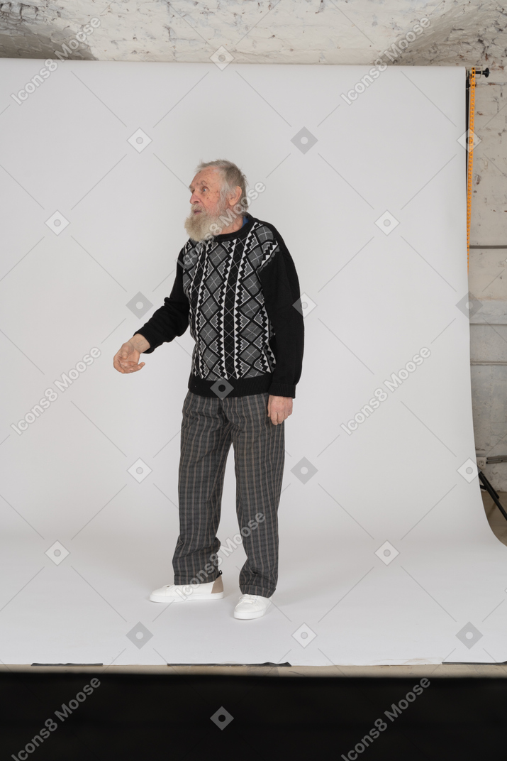Old man talking and holding hand raised