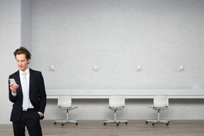 A man in a suit standing in front of a row of chairs