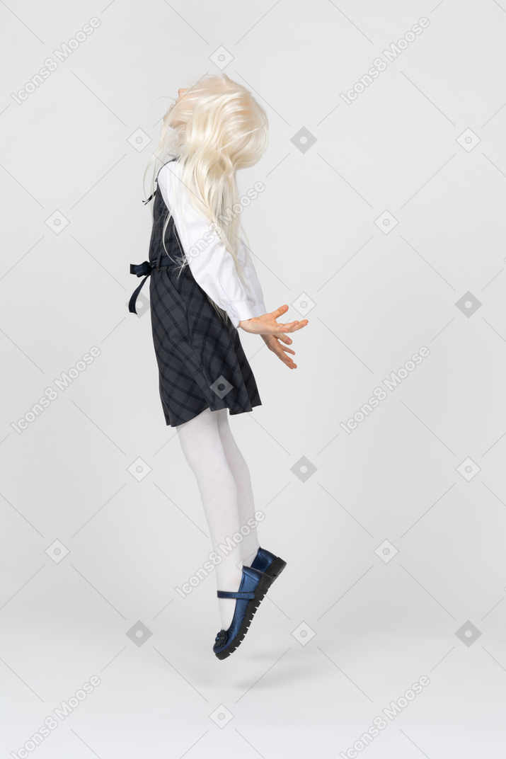 Schoolgirl jumping with arms at sides