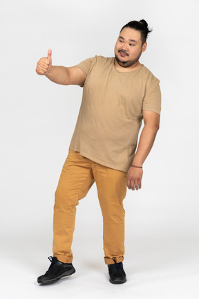 Positive asian man making thumb up gesture