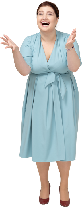 Vue de face d'une femme heureuse en robe bleue faisant des gestes