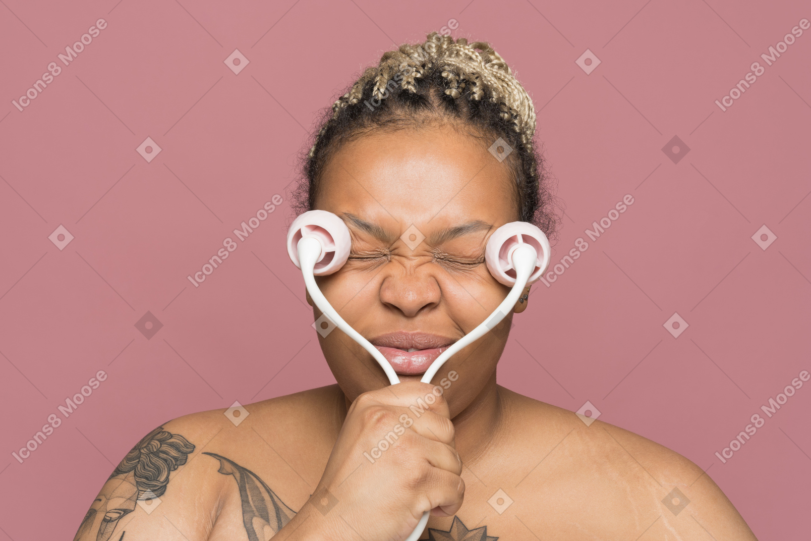 Mulher afro-americana sem camisa, aplicando um rolo de massagem de rosto