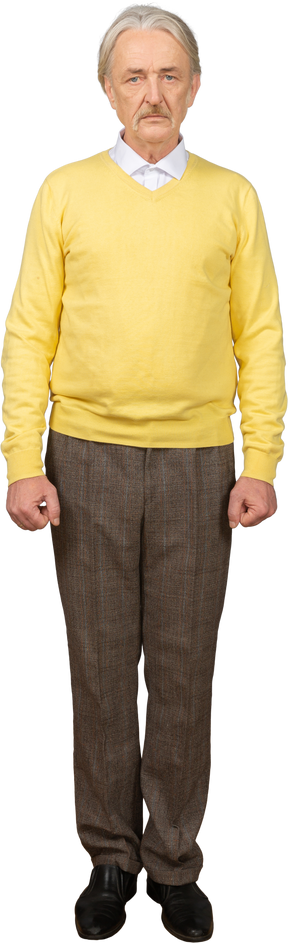 一个沮丧的老人，穿着一件黄色的套衫，看着相机的前视图