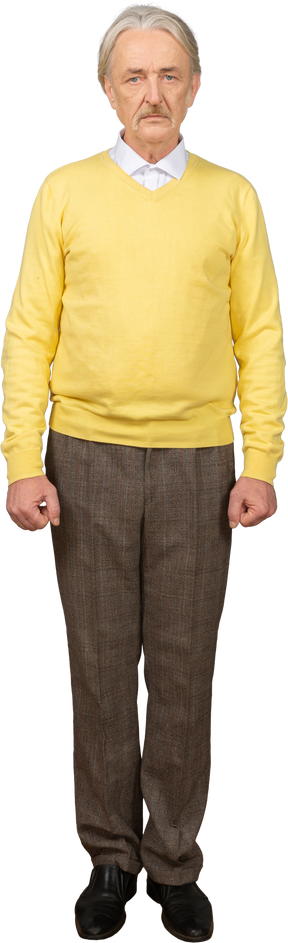 Front view of a depressed old man wearing a yellow pullover and looking at camera