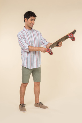 Young caucasian guy holding skate