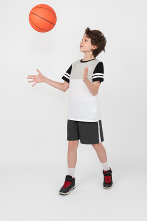 Niño moviendo y lanzando una pelota de baloncesto