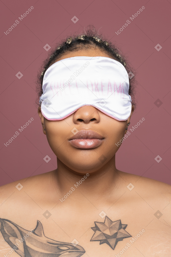 Portrait d'une femme tatouée en masque de sommeil