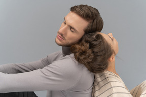 Couple sitting back to back with eyes closed