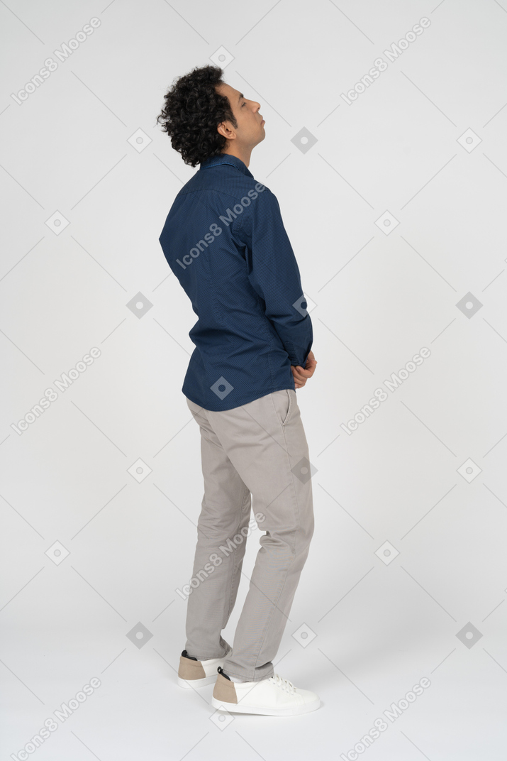 Vista lateral de um homem com roupas casuais olhando para cima