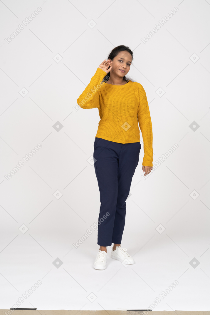 Front view of a girl in casual clothes standing with raised hand