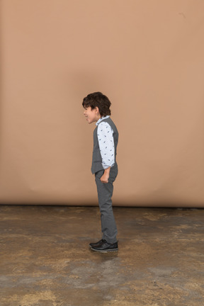 Boy in suit standing in profile