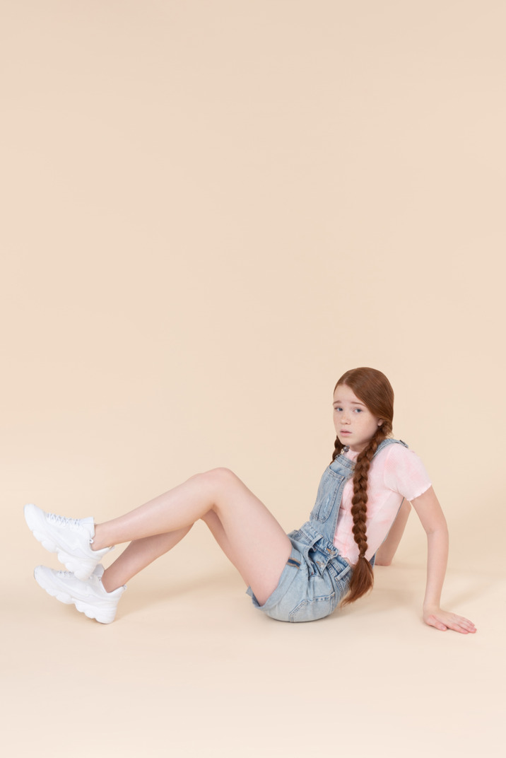 Sad looking teenage girl sitting on the floor