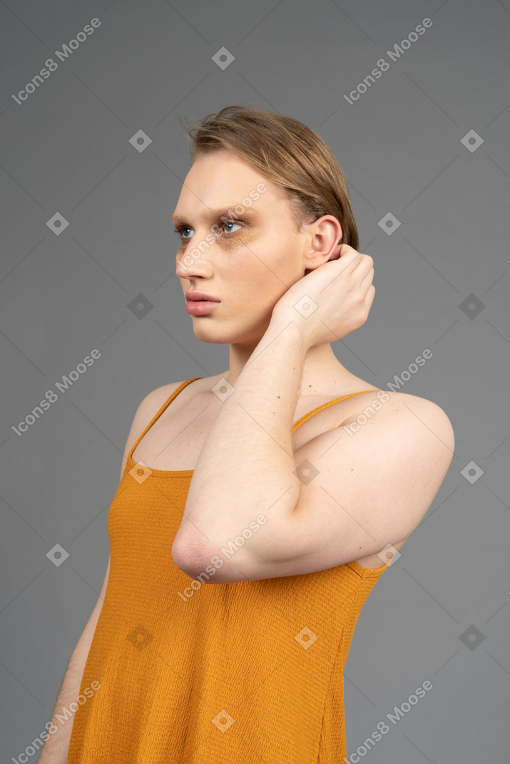 Young non-binary person touching their hair