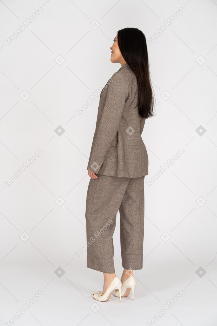 茶色のビジネススーツで笑顔の若い女性の4分の3の背面図