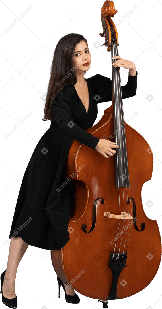 Vista frontale di una giovane donna in abito nero che suona il suo contrabbasso mentre guarda la fotocamera