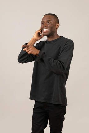 Homem alegre falando em um telefone imaginário