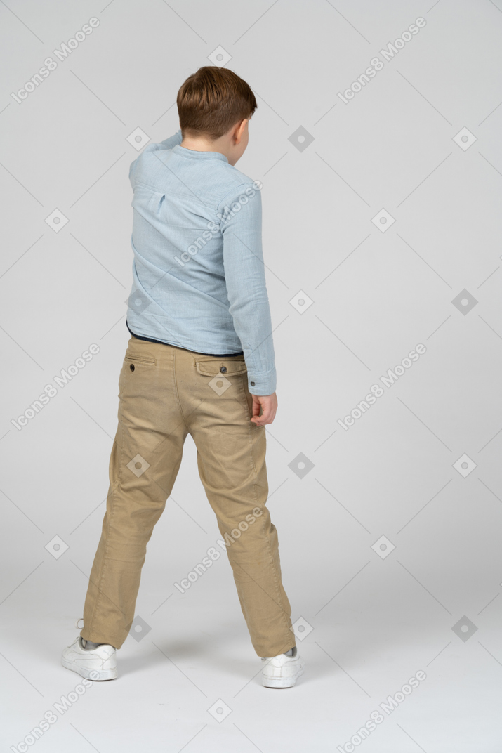 Back view of boy in blue shirt and khaki pants