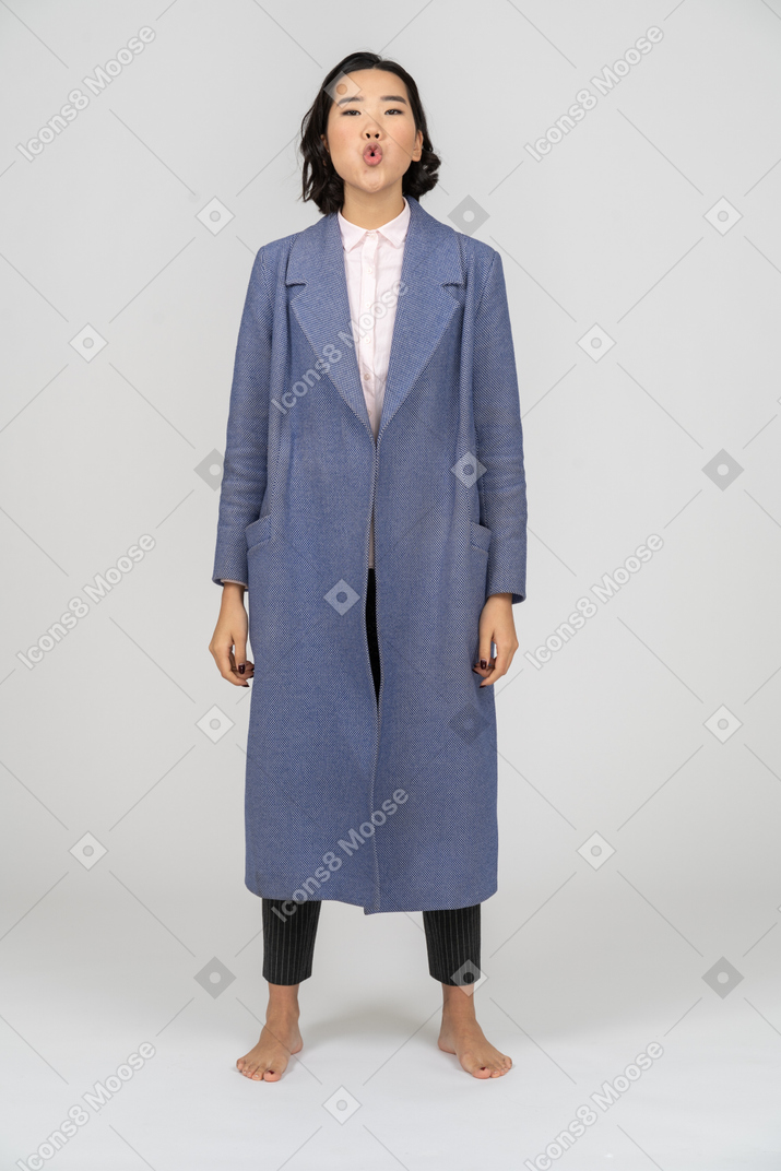 휘파람을 불고 있는 파란 코트를 입은 여자