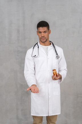 Young doctor offering a pill