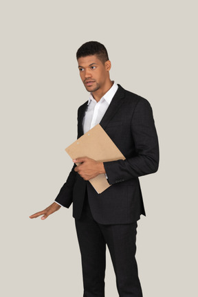 Office worker holding folder and showing height of something