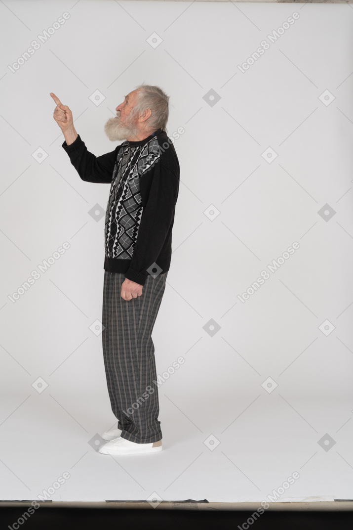 Side view of old man pointing up