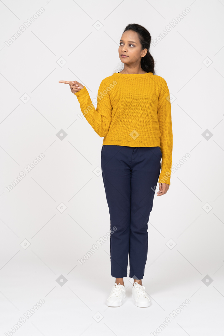 Front view of a girl in casual clothes pointing with finger