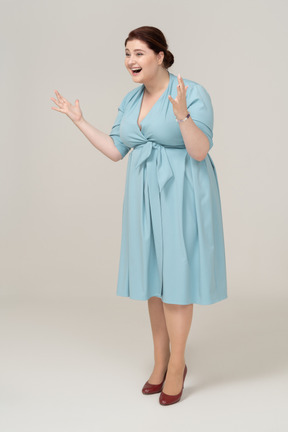 Femme heureuse en robe bleue posant de profil