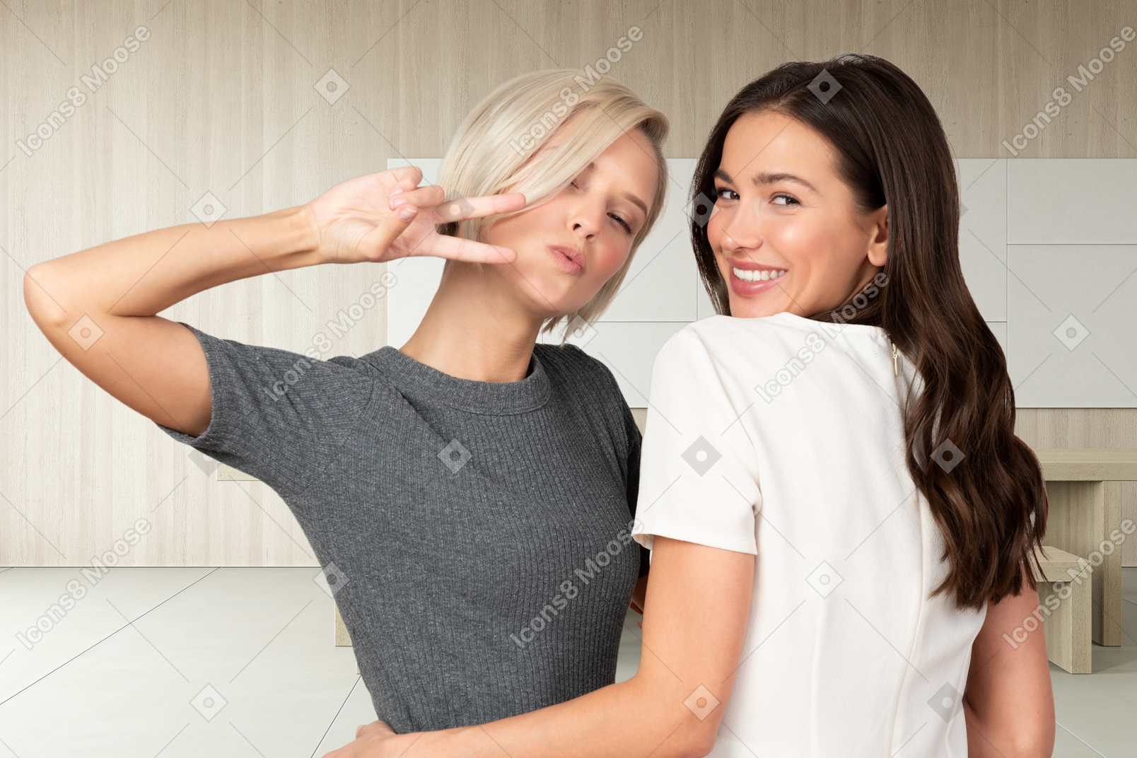Two women hugging and making a peace sign