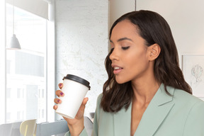 A woman holding a cup of coffee in her hand