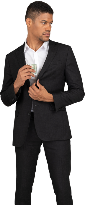 Front view of a young man in black suit holding bank card