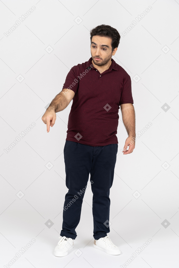 Hombre con ropa informal apuntando hacia abajo