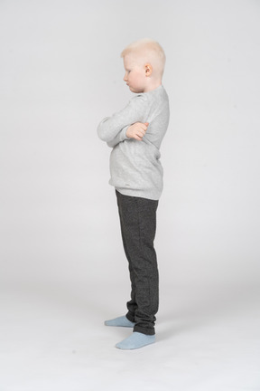 Side view of a little boy with crossed hands