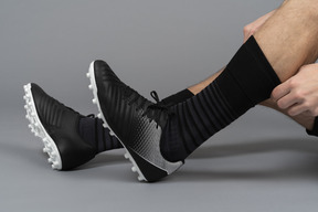 Close-up of a soccer player adjusting his knee socks