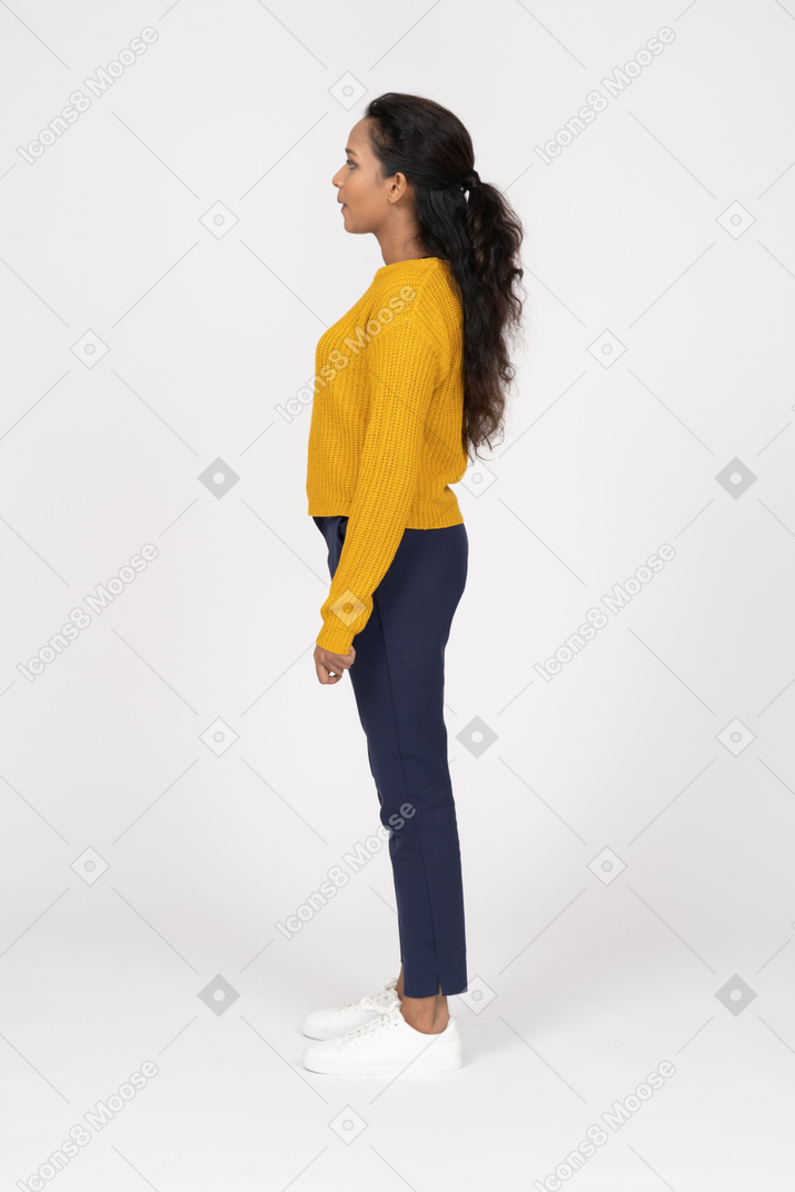Girl in yellow shirt standing in profile