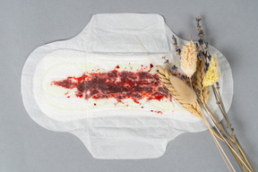 Dried flowers over a used sanitary pad