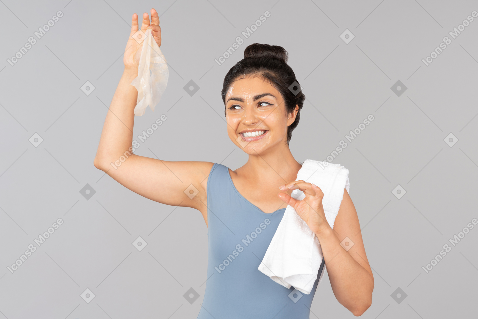 Indian woman holding face mask and white towel on shoulder