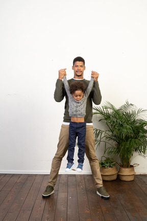 Good looking young man playing with a boy